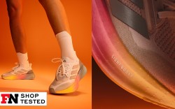 runner wearing adidas sneakers on an orange background; close up shot of adidas running shoe midsole