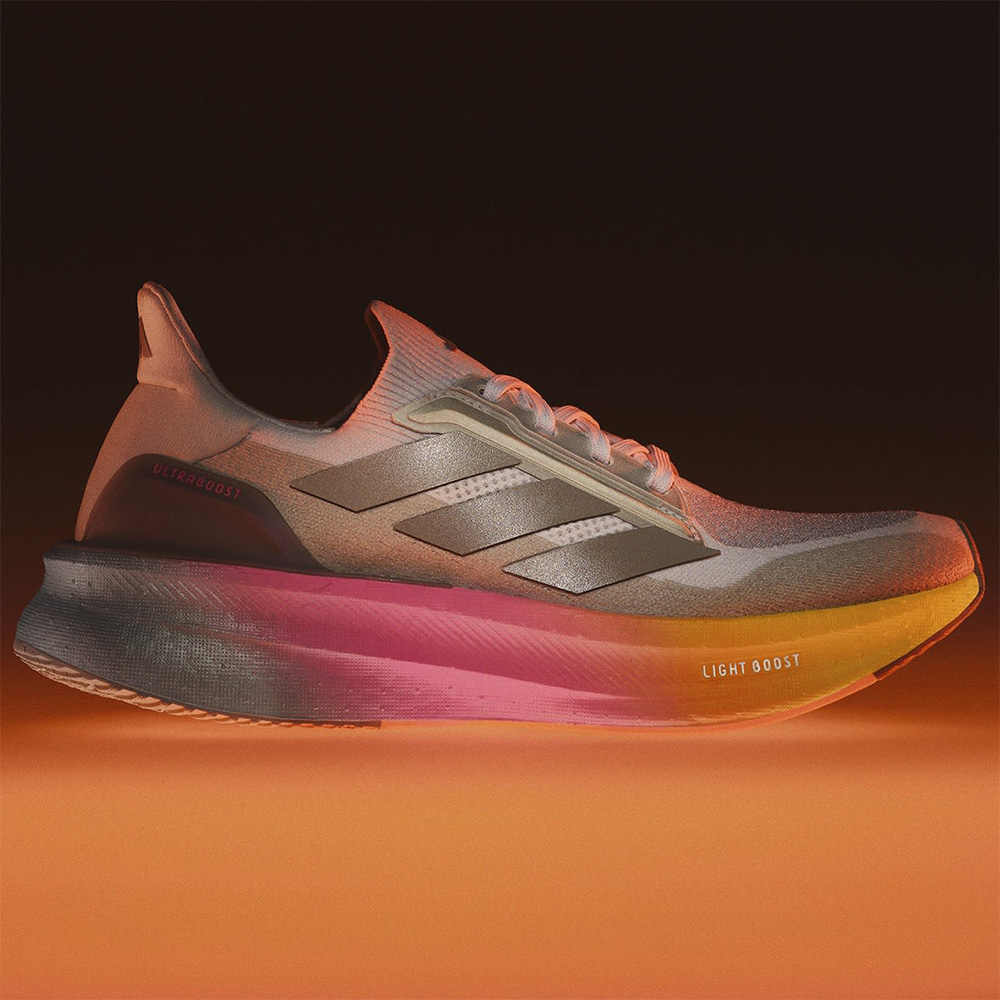 profile view of adidas running sneakers on an orange and black background