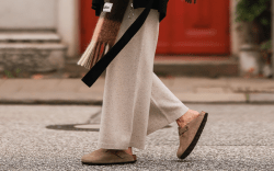 close-up image of a woman wearing Birkenstock Boston Clogs, beige pants, and a plaid scarf in Hamburg, Germany.