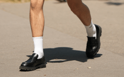 PARIS, FRANCE - JUNE 24: A guest wears black sunglasses, a white tank-top, a black short sleeves shirt from Balenciaga, black suit pants, a silver small chain bracelet from Tiffany, white socks, black shiny leather loafers , outside Hermes, during the Menswear Spring/Summer 2024 as part of Paris Fashion Week on June 24, 2023 in Paris, France.