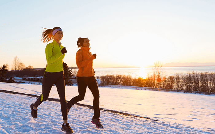 two people running on snowy road